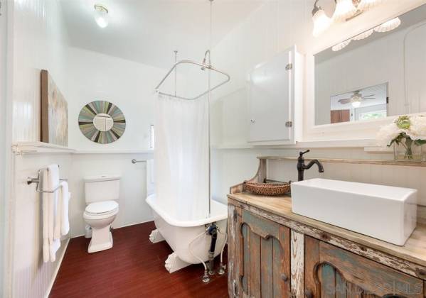 Remodeled bathroom features original bathtub that has been refinished.