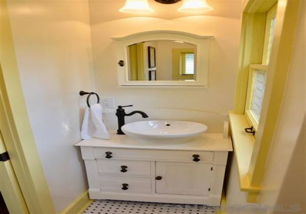 Bathroom in granny flat features a new sink, walk in shower, windows and toilet.